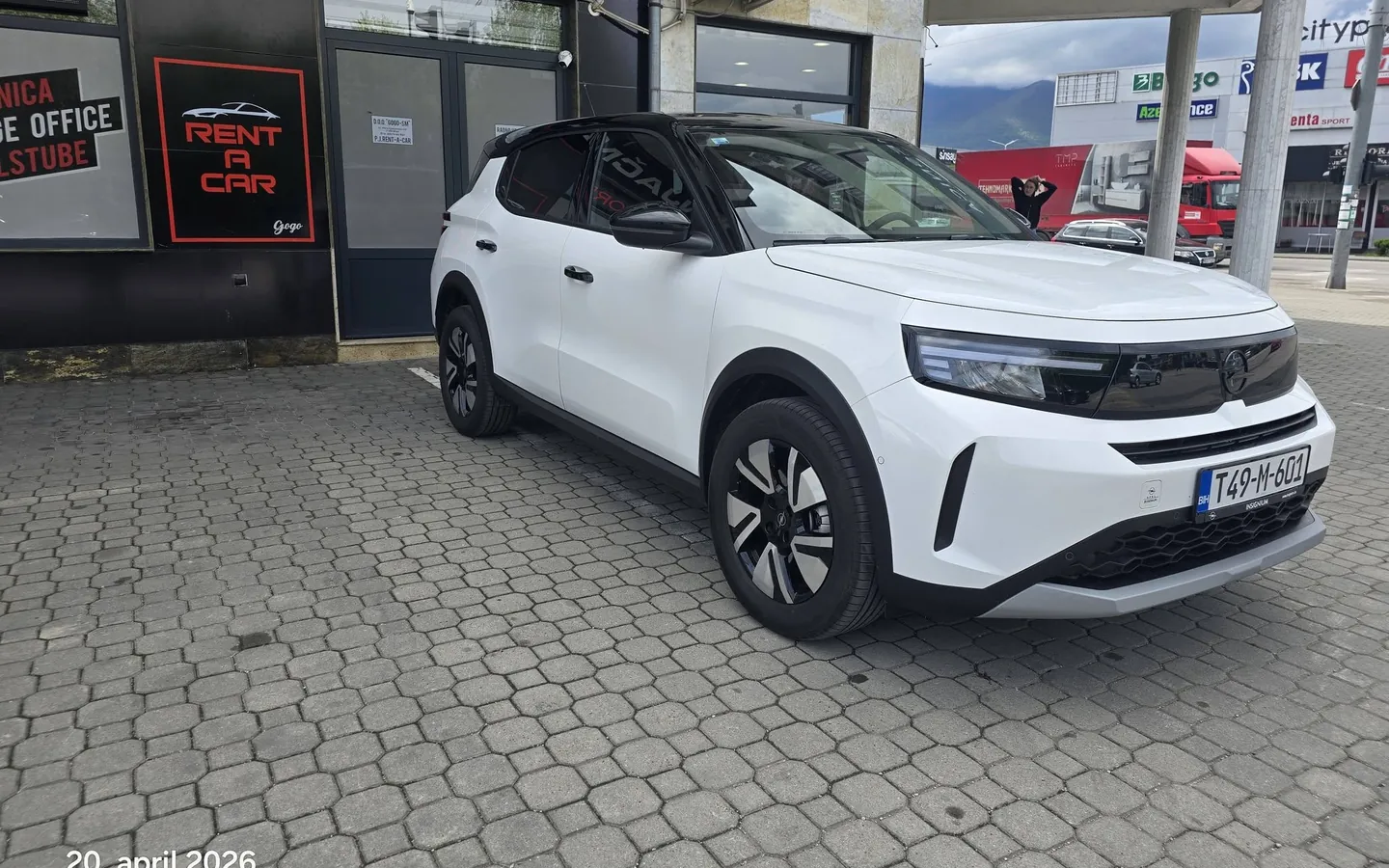 Opel Frontera (bijela s crnim krovom) أمام مكتب Rent a Car Gogo في بيهاتش